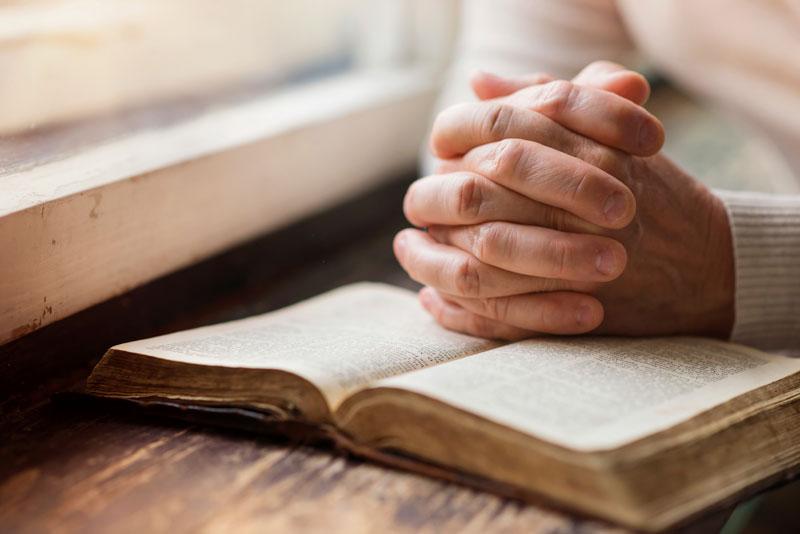 Man praying with Bible